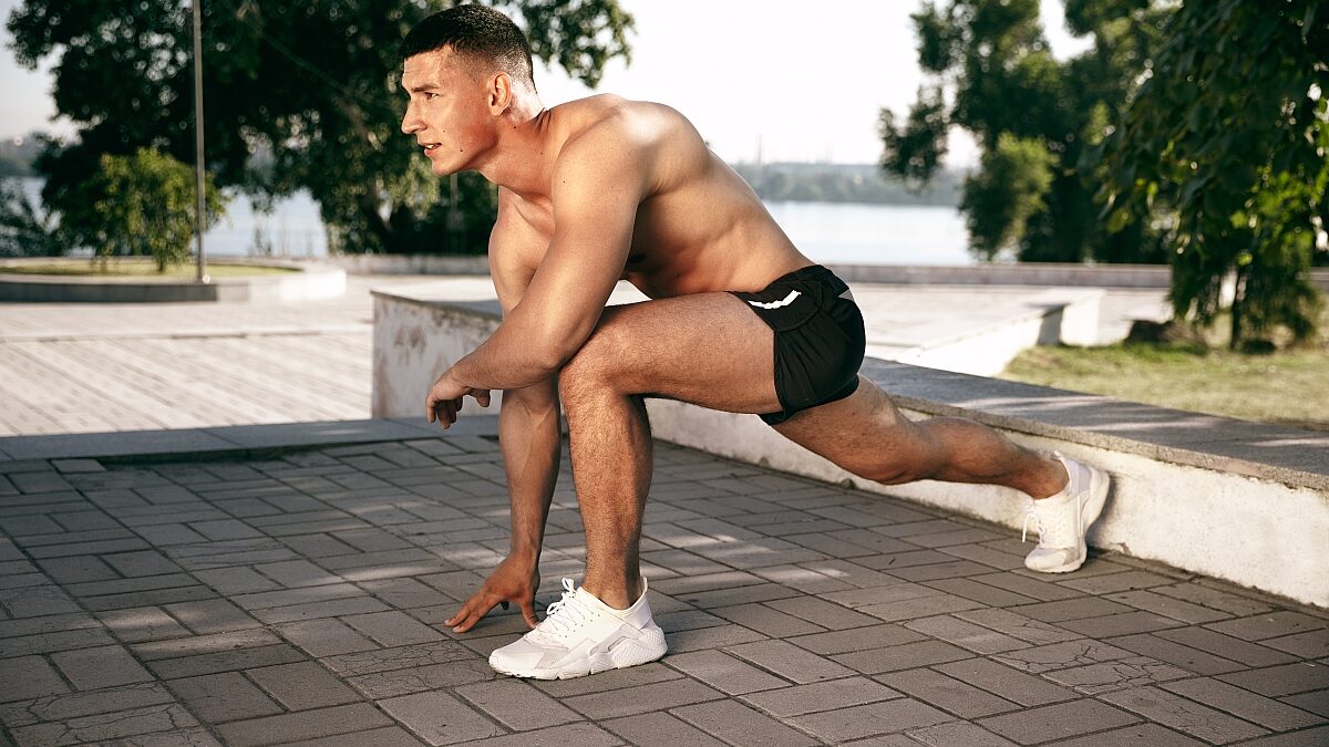 muscular male athlete doing workout park gymnastics training fitness workout flexibility summer city sunny day space field
