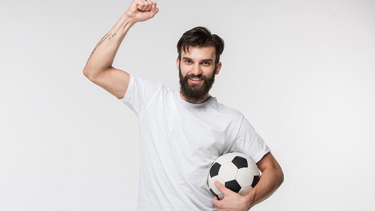 young soccer player with ball front white wall