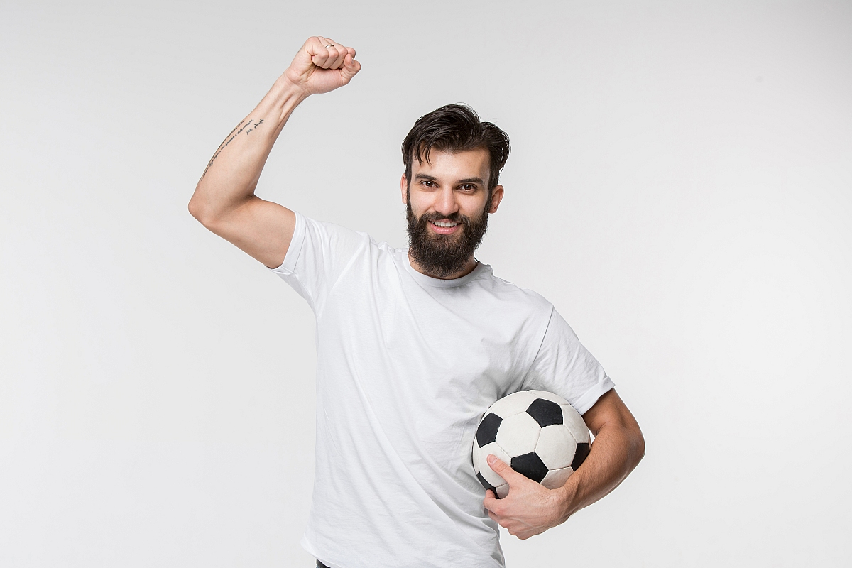 young soccer player with ball front white wall