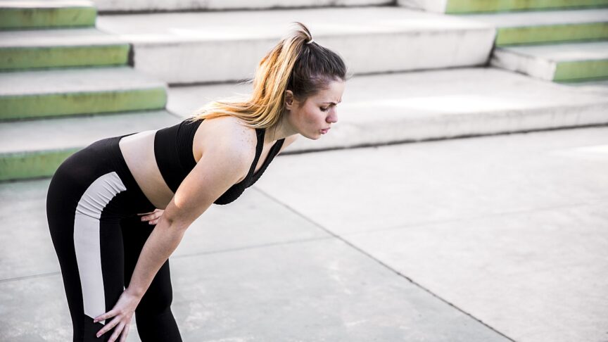 young woman stretching street