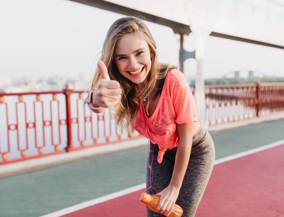 fascinating female runner posing with thumb up portrait lovable caucasian girl enjoying morning training