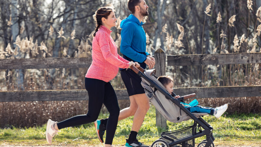 shot sporty young couple with her little son running while enjoying time together outdoor